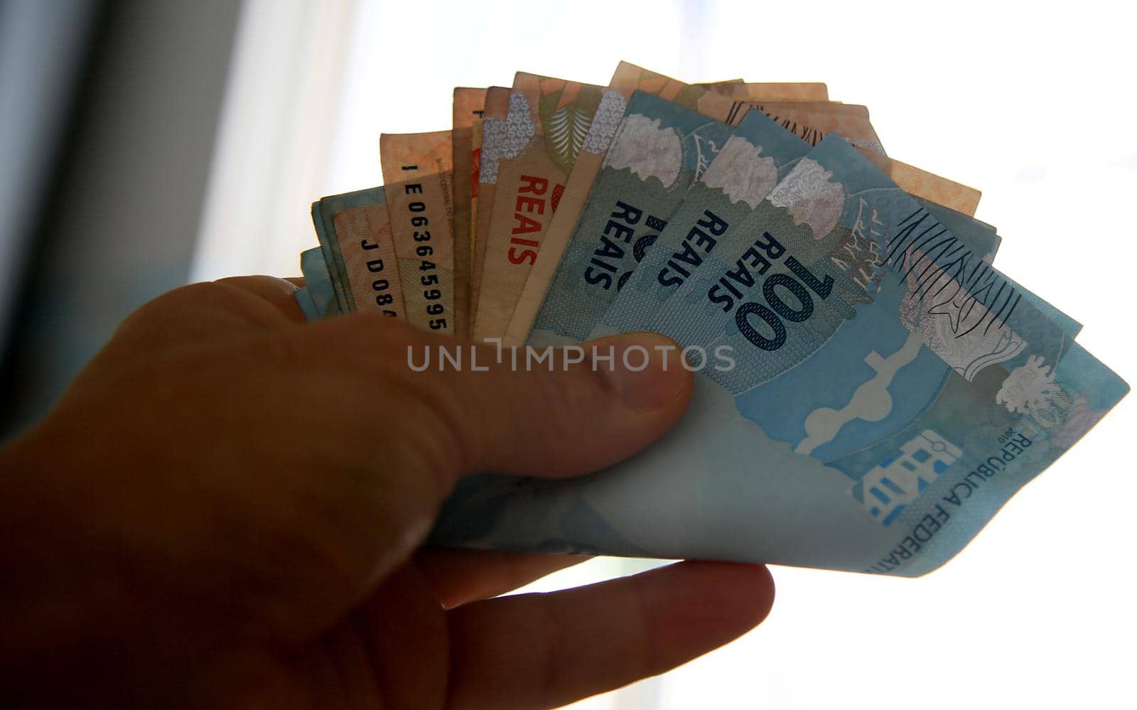 salvador, bahia / brazil - march 28, 2020: woman's hands hold reais banknotes, currency used in Brazil.