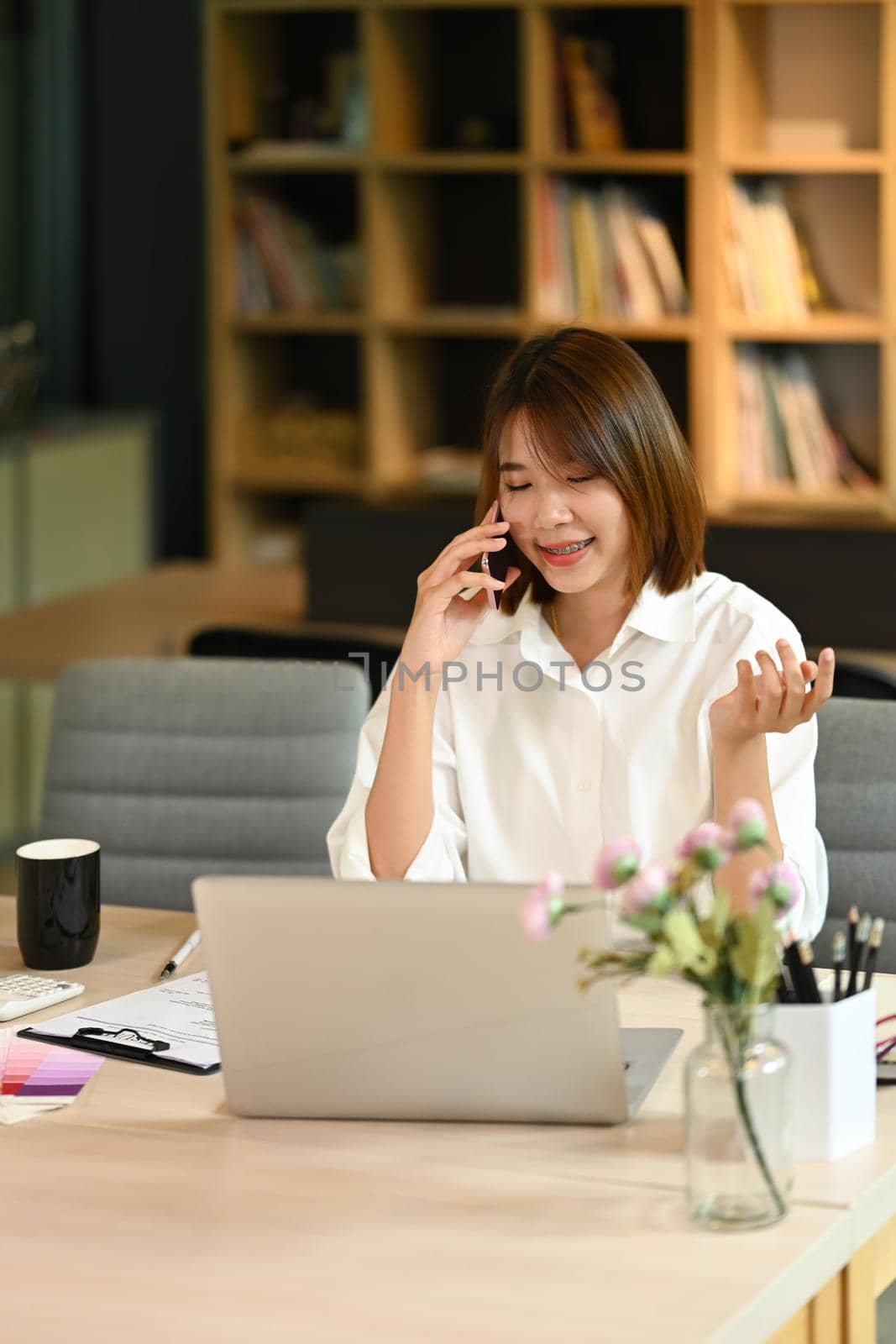 Pretty young entrepreneur having phone conversation, negotiations with business partner on mobile phone.