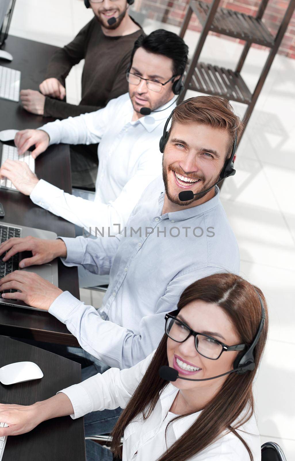 close up.smiling call center specialists in the workplace by asdf