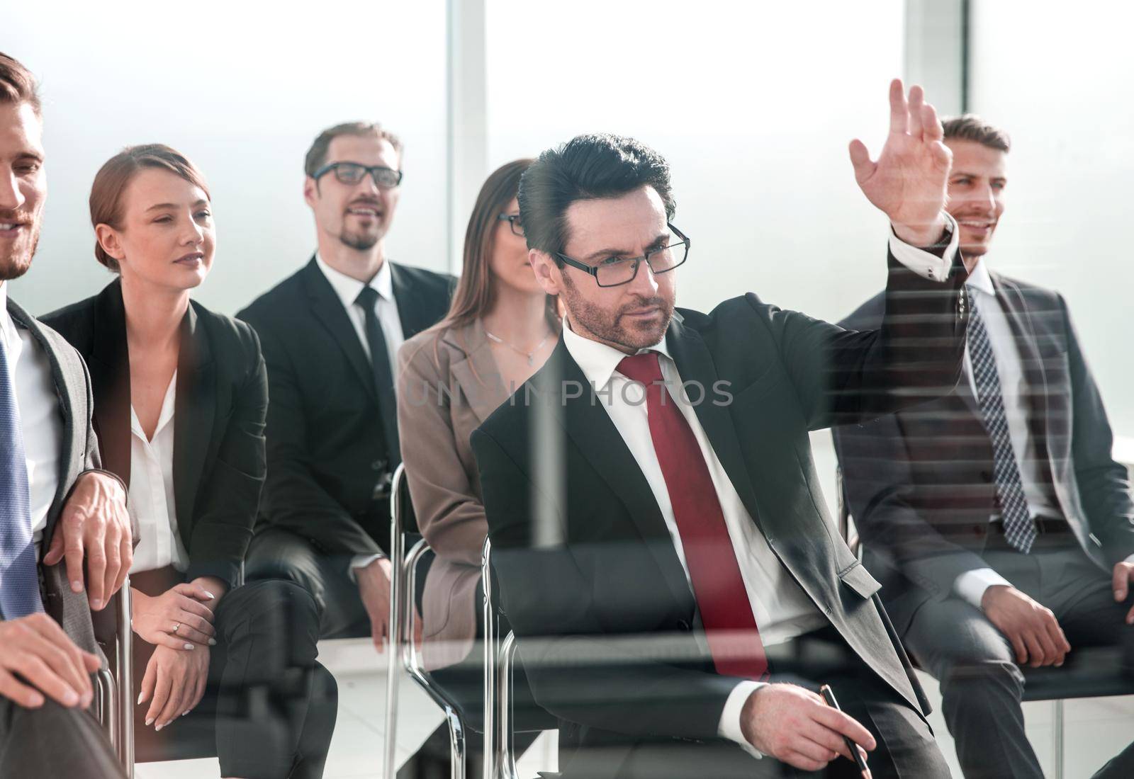 Businessman raises his hand at the conference