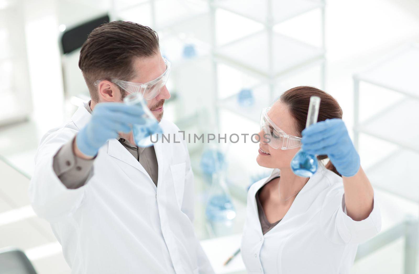 happy scientist and assistant show tube with liquid.photo with copy space