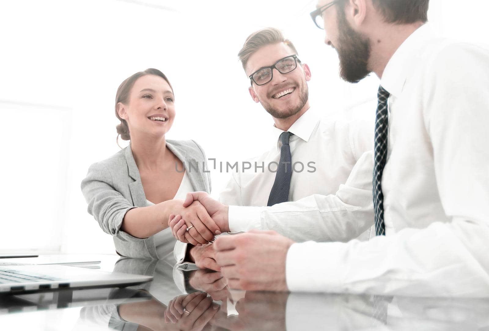 background image.handshakes colleagues at the Desk .business concept
