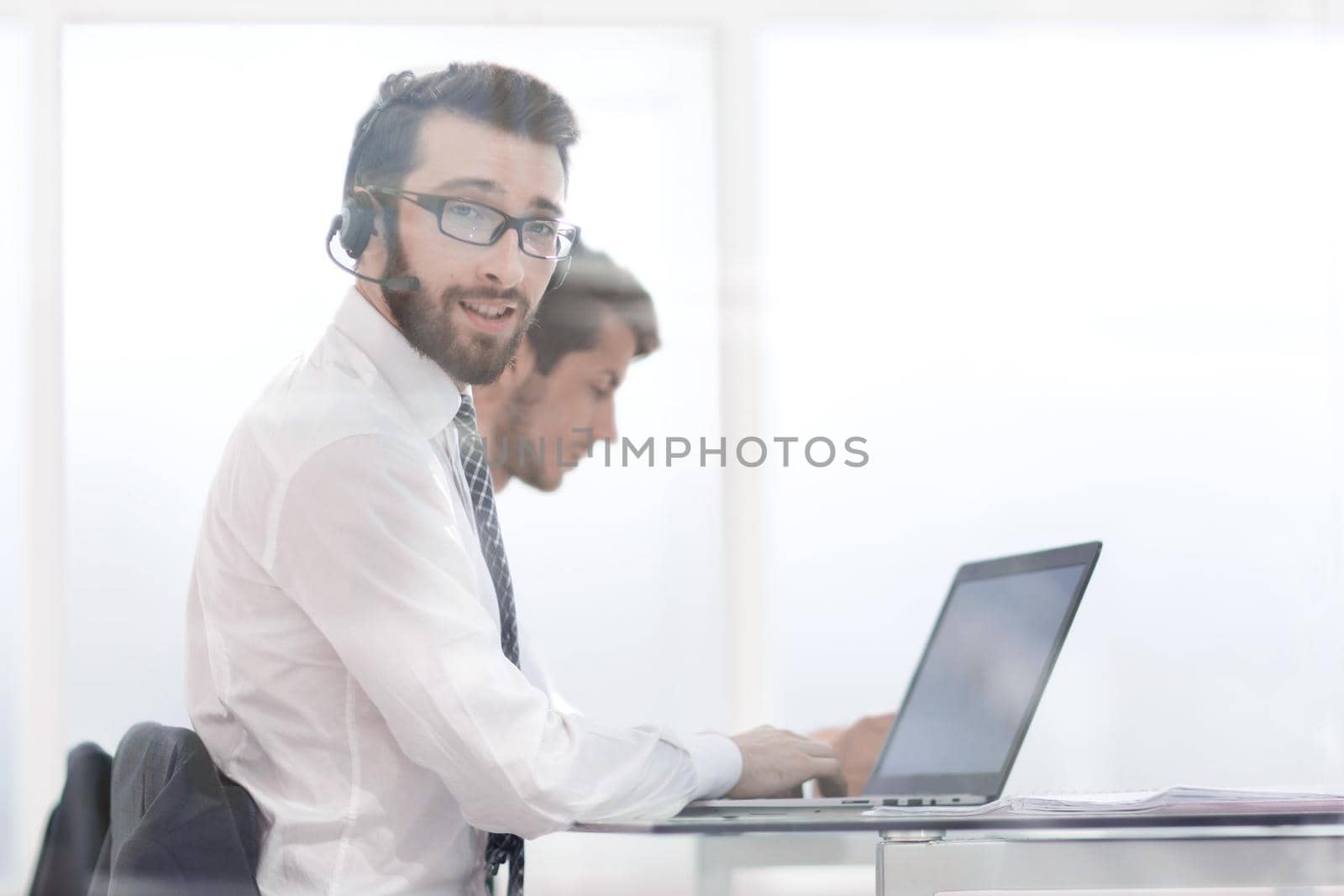 business man in headphones sitting at his Desk.photo with copy space.