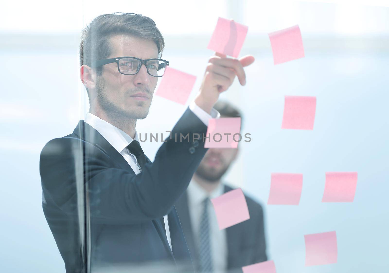 serious employee reads a sticker-note on the office Board.business concept