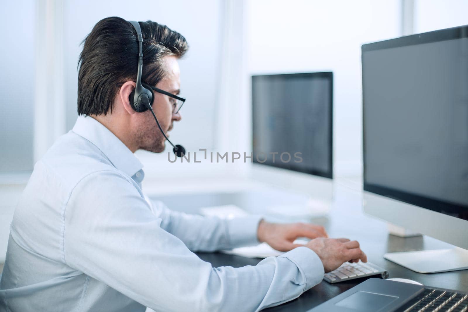 close up.businessman with a headset works in a modern office.people and technology