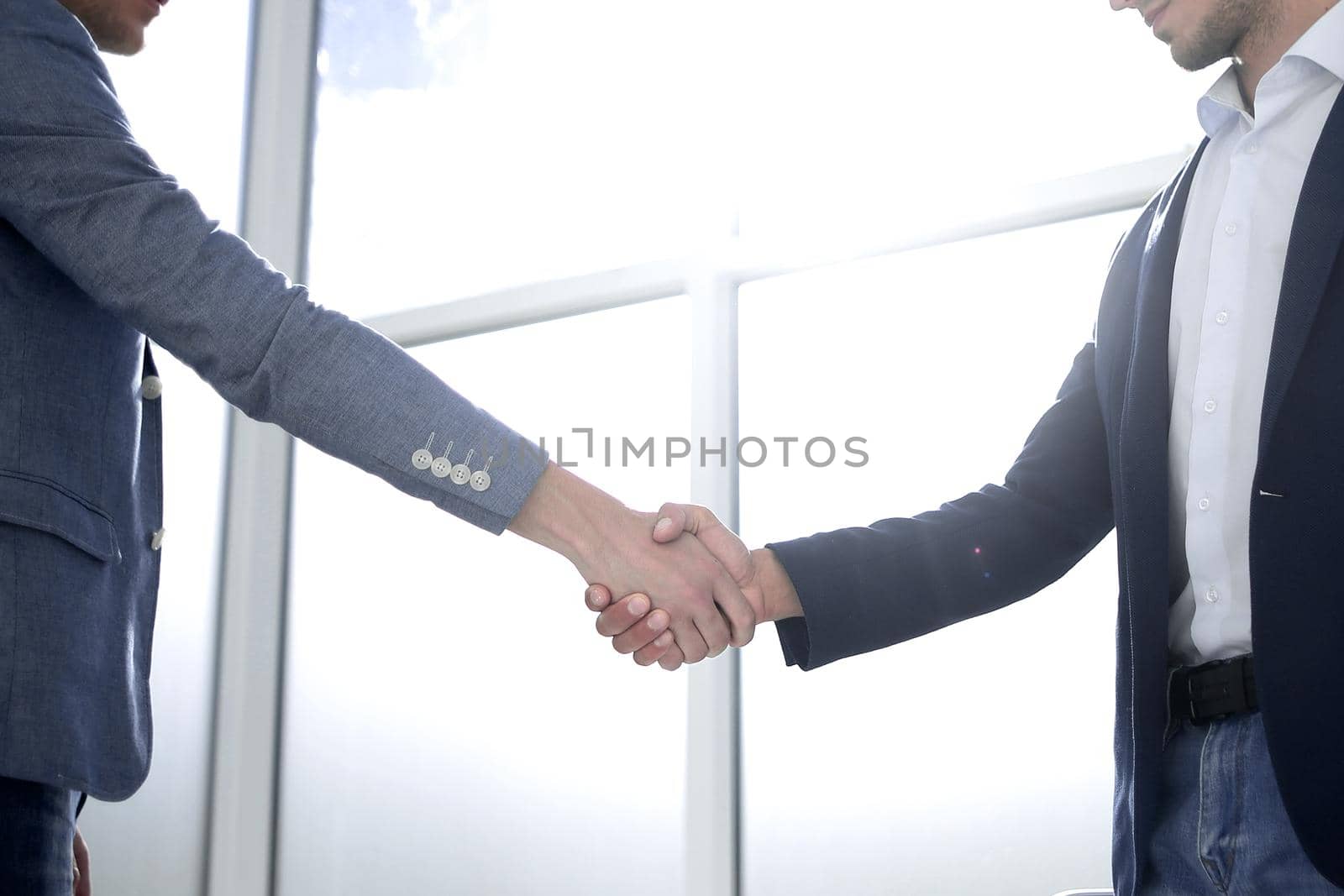 business people shaking hands in a bright office by asdf