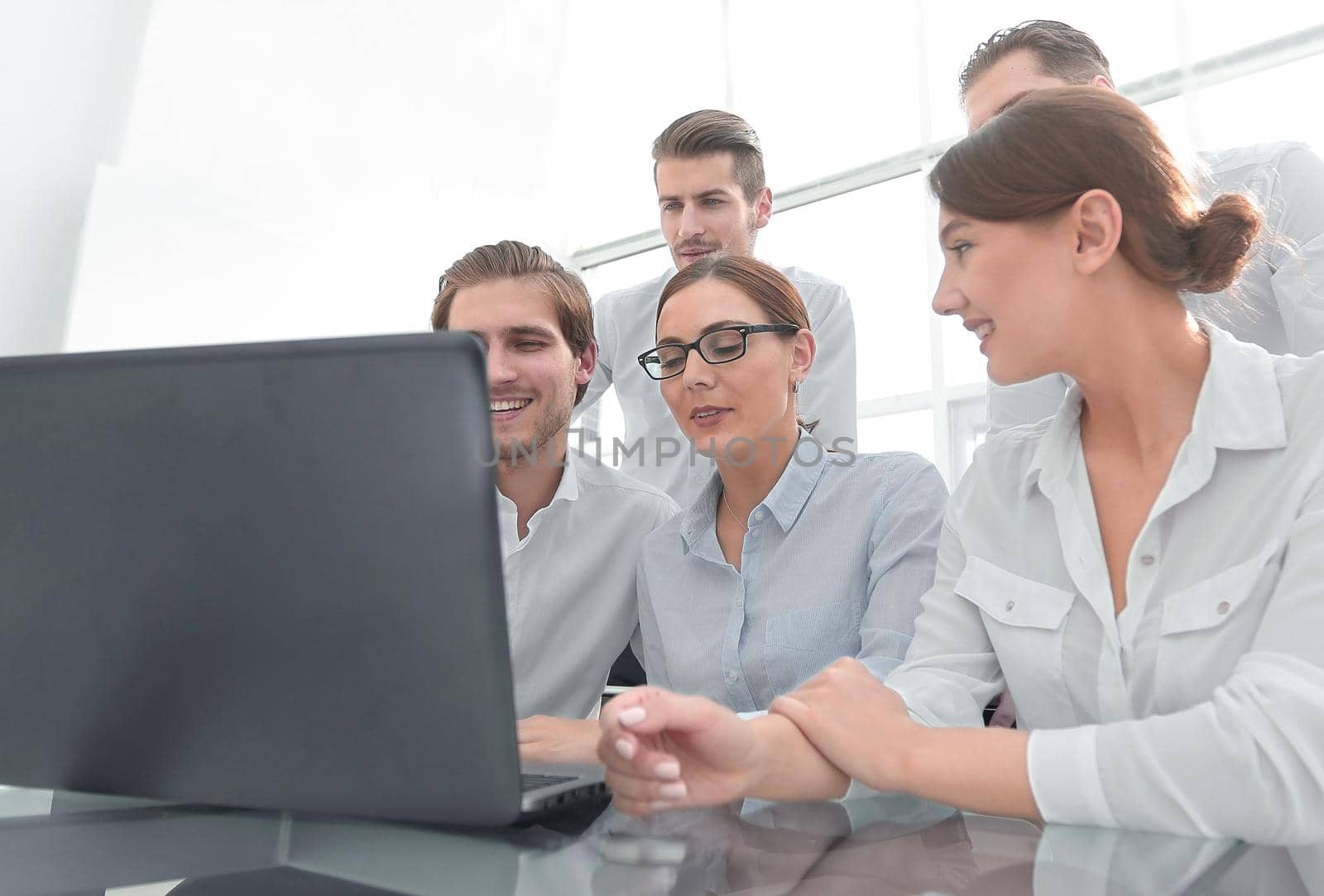 business team looks at the laptop screen. people and technology