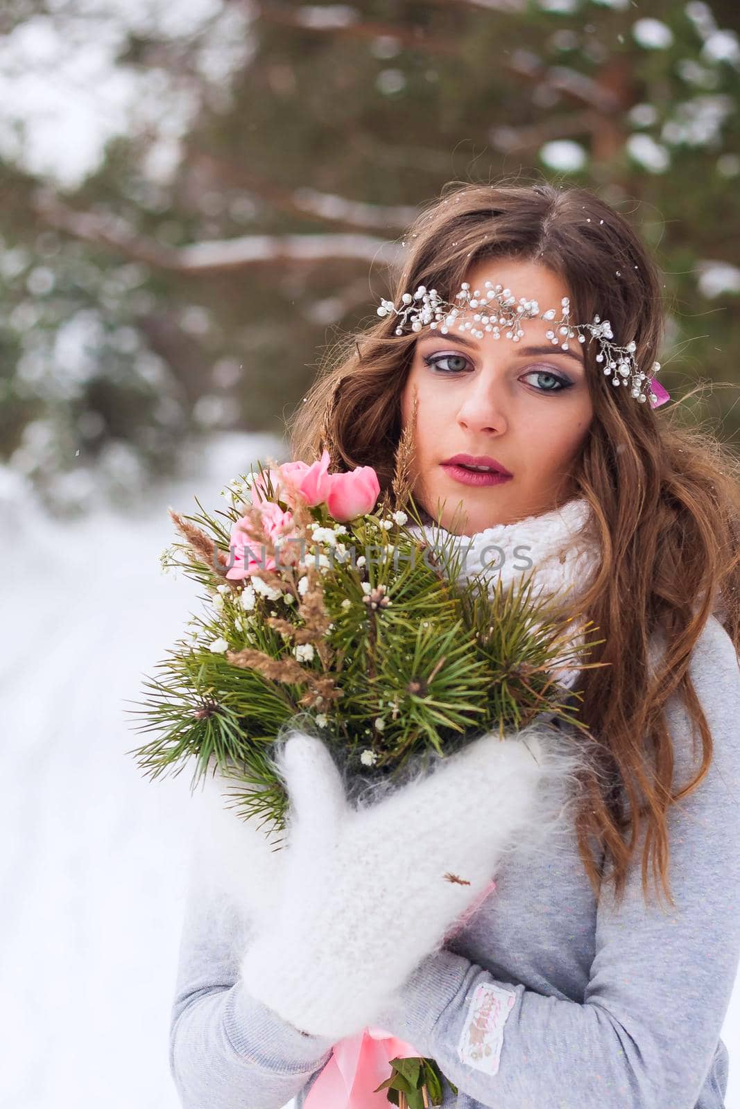 Beautiful bride in a white dress with a bouquet in a snow-covered winter forest. Portrait of the bride in nature. by Annu1tochka