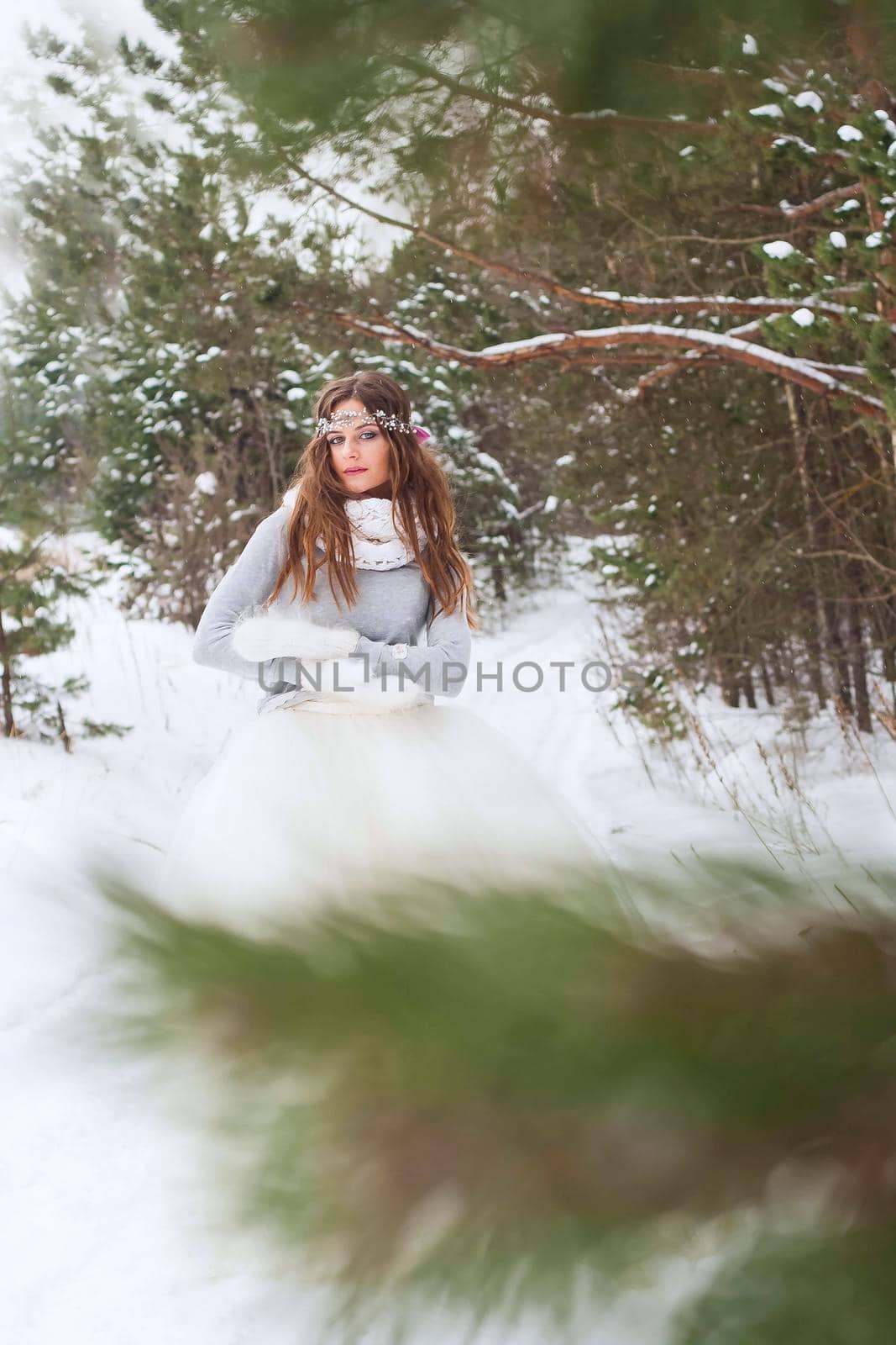 Beautiful bride in a white dress with a bouquet in a snow-covered winter forest. Portrait of the bride in nature. by Annu1tochka