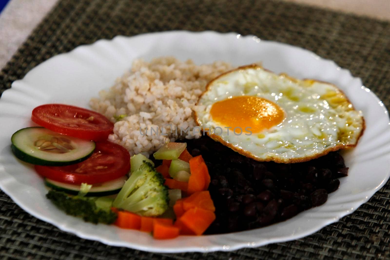 salvador, bahia, brazil - june 3, 2022: food plate with black beans, rice salad and fried egg.