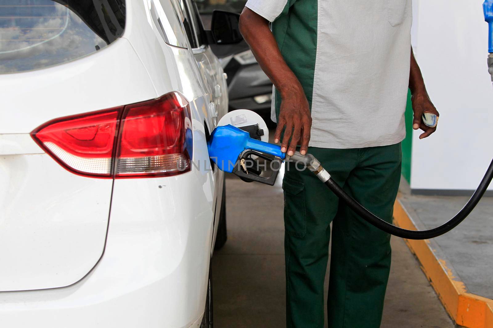 salvador, bahia, brazil - may 17, 2022: gas station attendant fills up with gasoline and vehicle at a gas station in the city of Salvador.