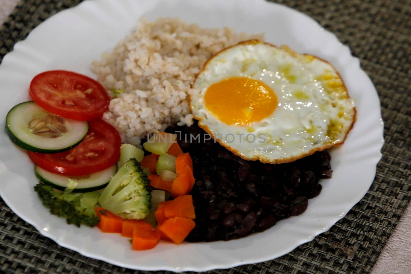 salvador, bahia, brazil - june 3, 2022: food plate with black beans, rice salad and fried egg.
