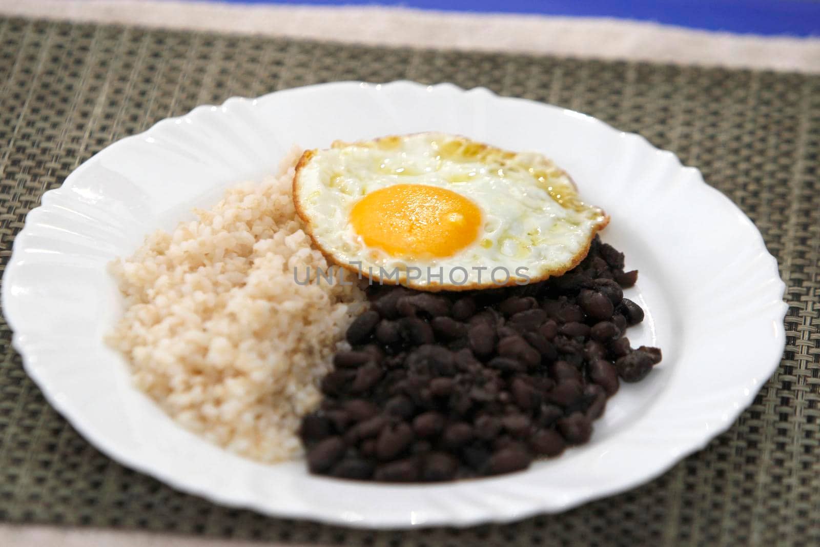 salvador, bahia, brazil - june 3, 2022: food plate with black beans, rice salad and fried egg.