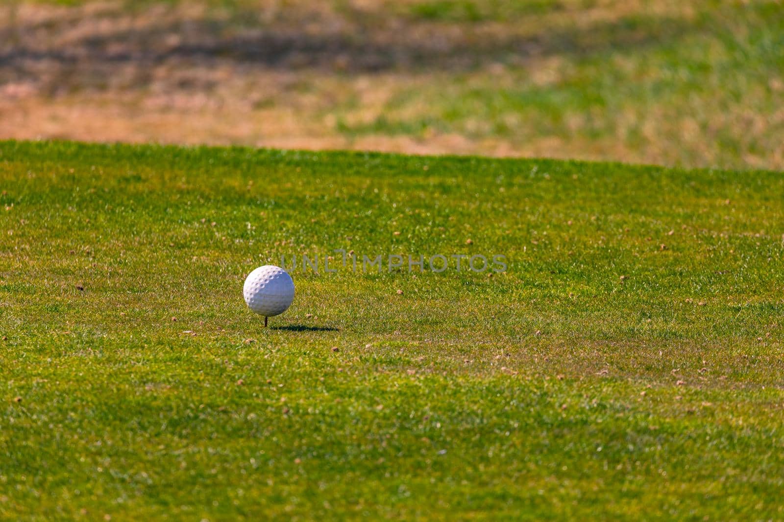 A white golf ball shows on a green where the tee off takes place on the German 18-hole golf course