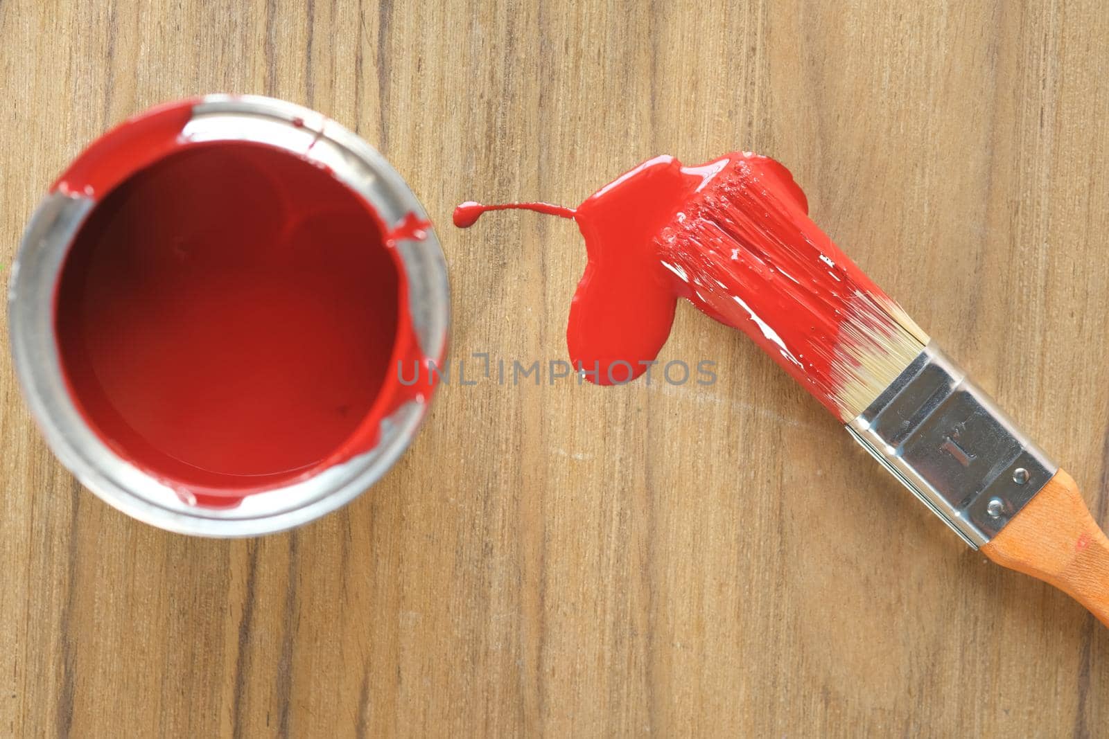 A paint brush , gloves and paint on table .