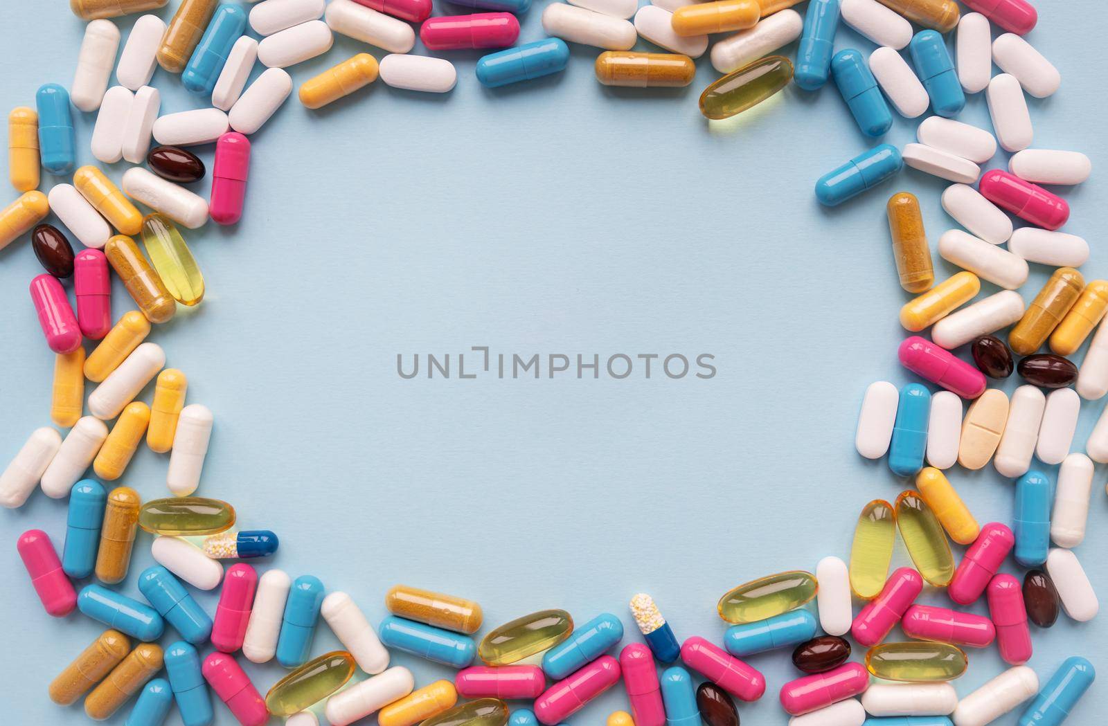 A lot of multi-colored bright tablets, in the center there is a place for an inscription. Blue background. Concepts of medicine and health. by sfinks