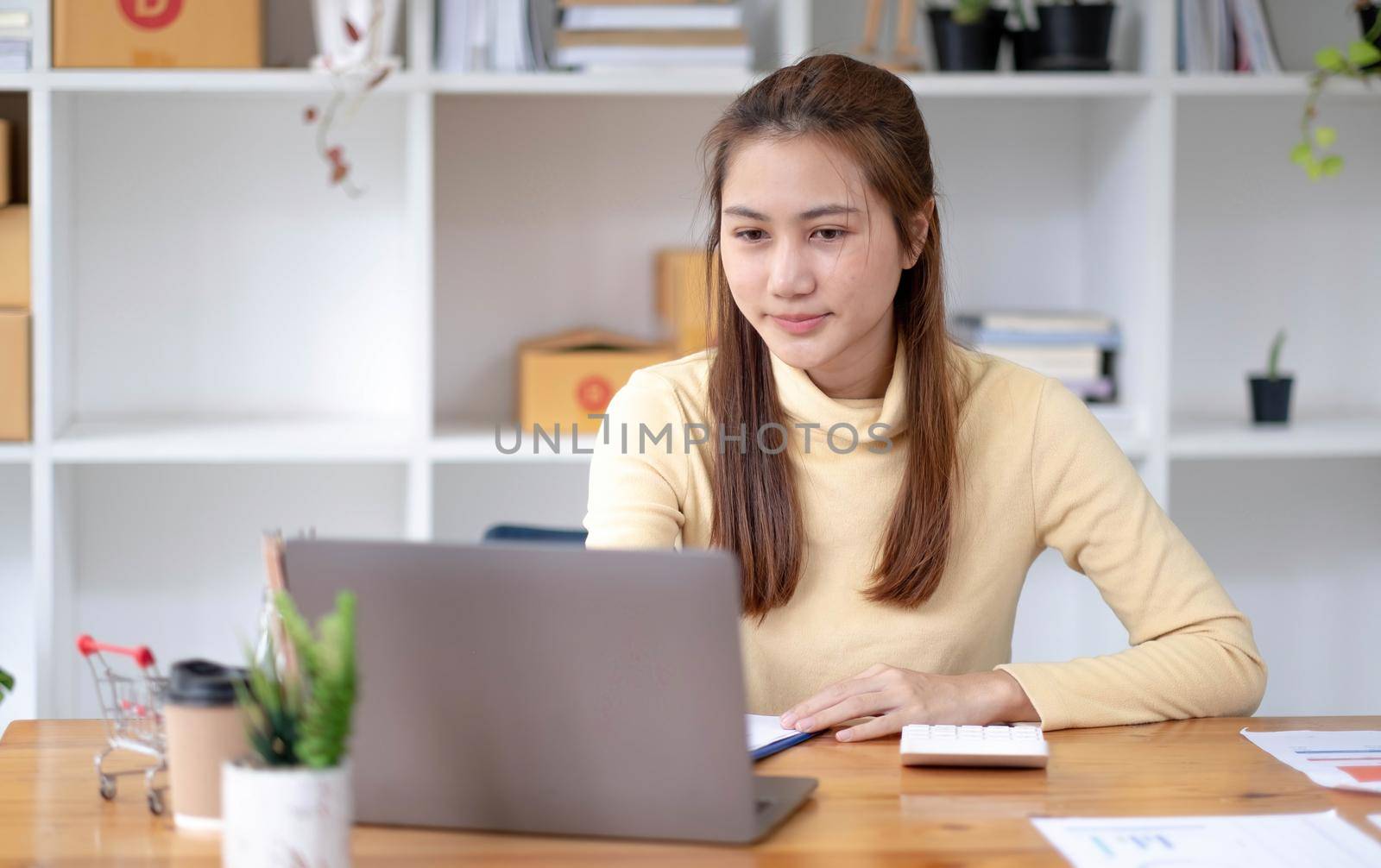 Portrait of Starting small businesses owners female entrepreneurs working on receipt box and check online orders to prepare to pack the boxes, sell to customers, sme business ideas online. by wichayada