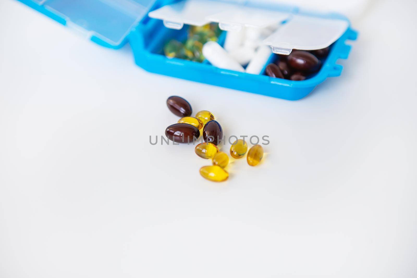 Pouring pills and capsules on a white background close-up. Top view with copy space. Medicine concept. by sfinks