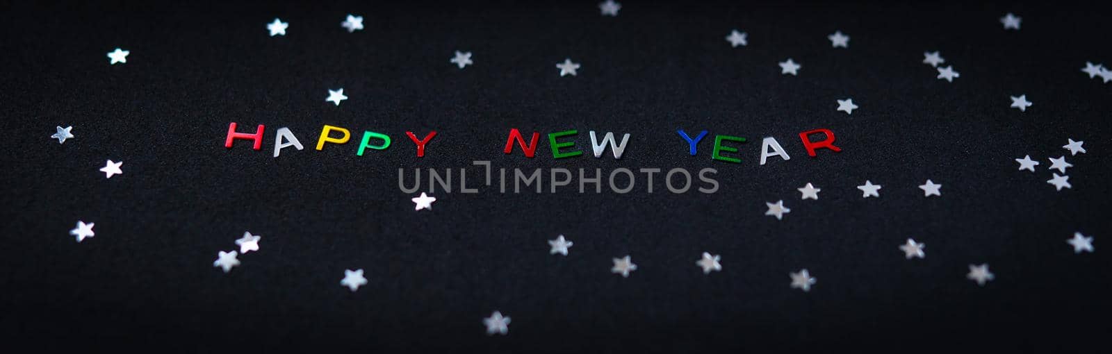 Happy new year inscription in multicolored shiny letters, together with silver stars. New Year card. by sfinks