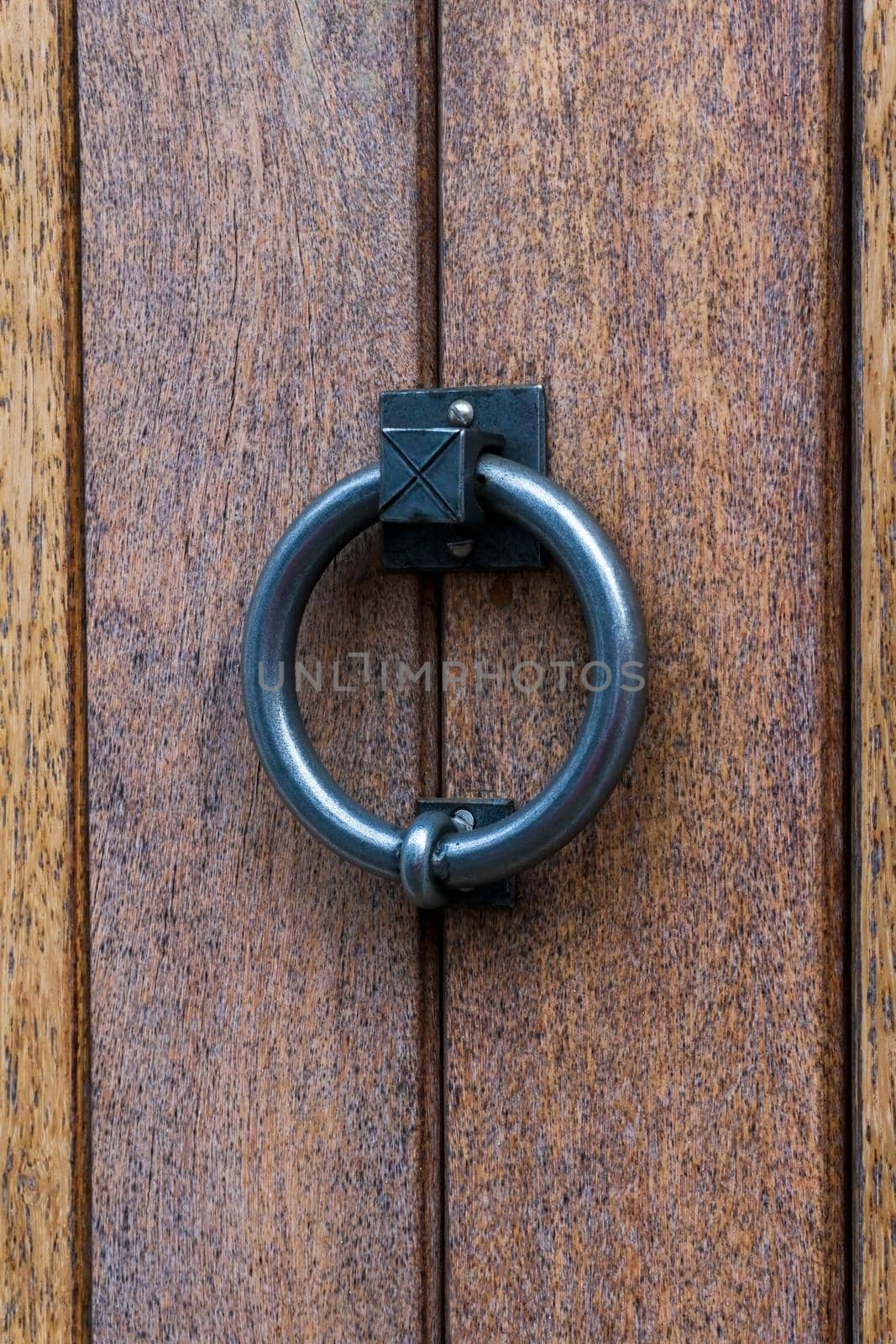 Metal ring door knocker on a wooden door close up