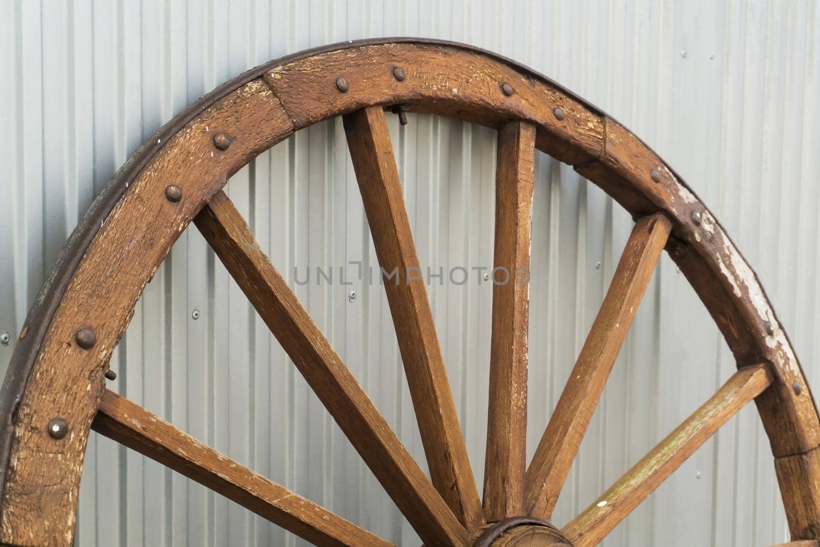 Antique wooden wheel on metallic background close up