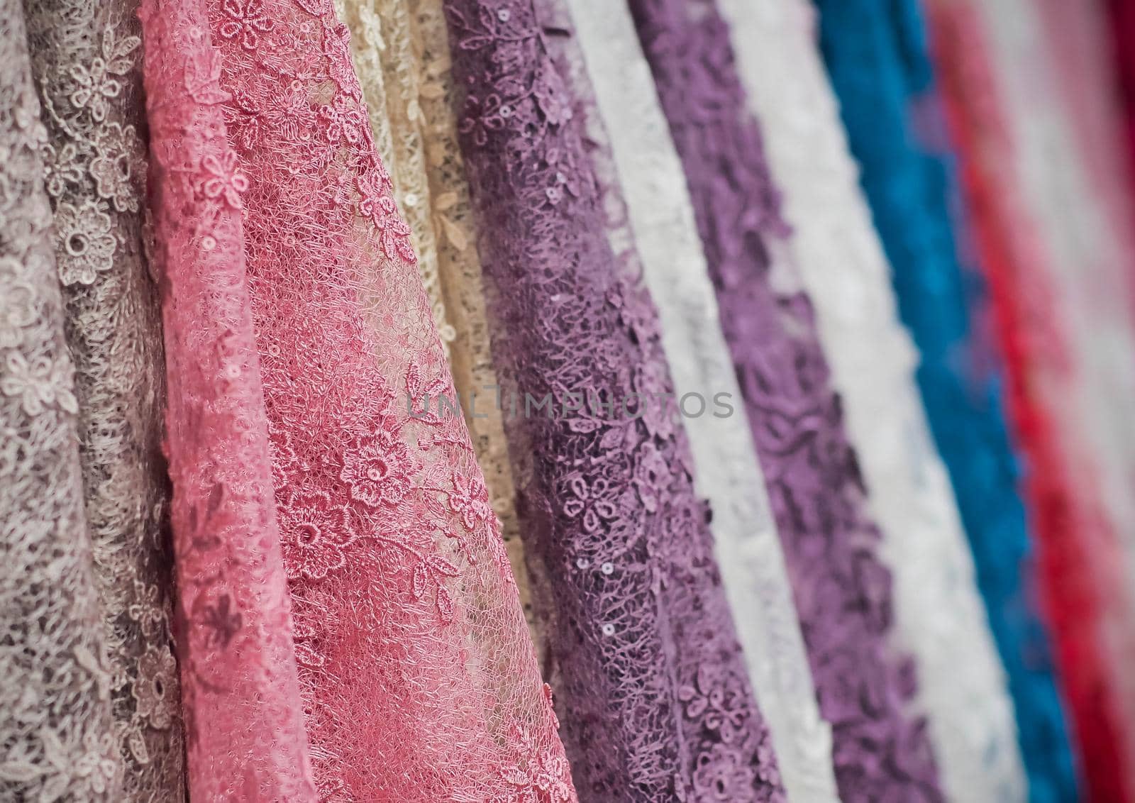 colorful fabric lace fabric rolls in textile shop industry.Rolls of bright colored fabric