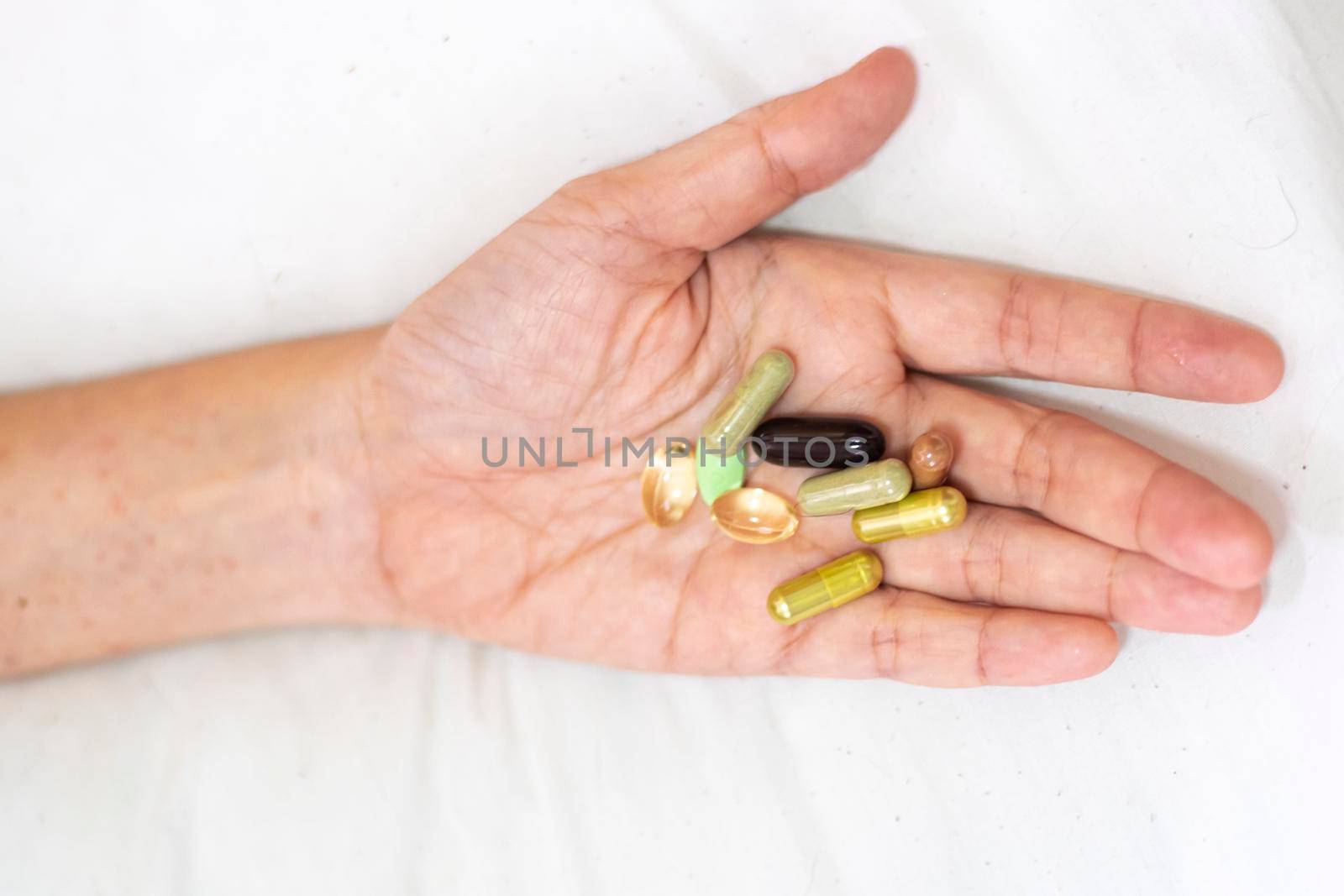 Close up supplement food in hand. Health care concept on white background.