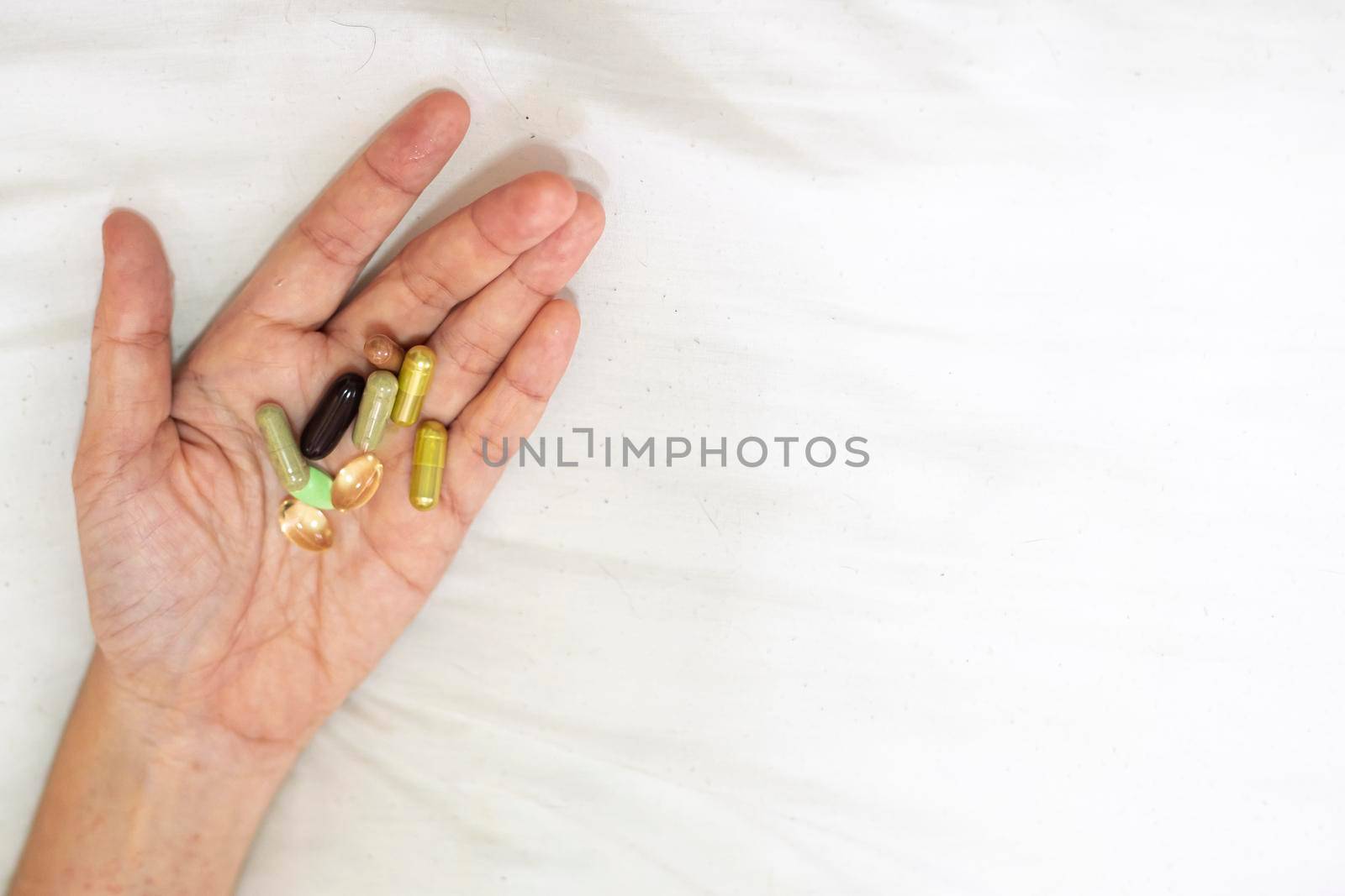 Close up supplement food in hand. Health care concept on white background.