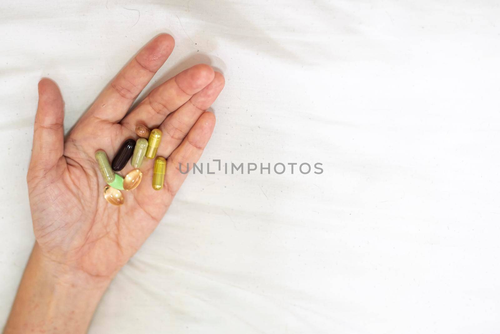 Close up supplement food in hand. Health care concept on white background. by Petrichor