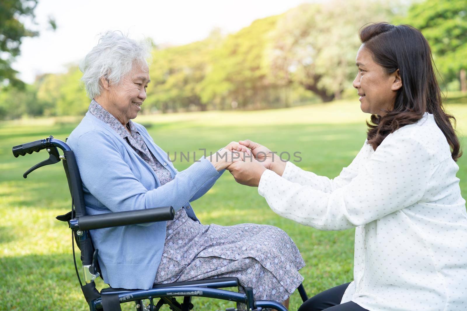 Holding hands Asian senior or elderly old lady woman patient with love, care, encourage and empathy at nursing hospital ward, healthy strong medical concept by pamai