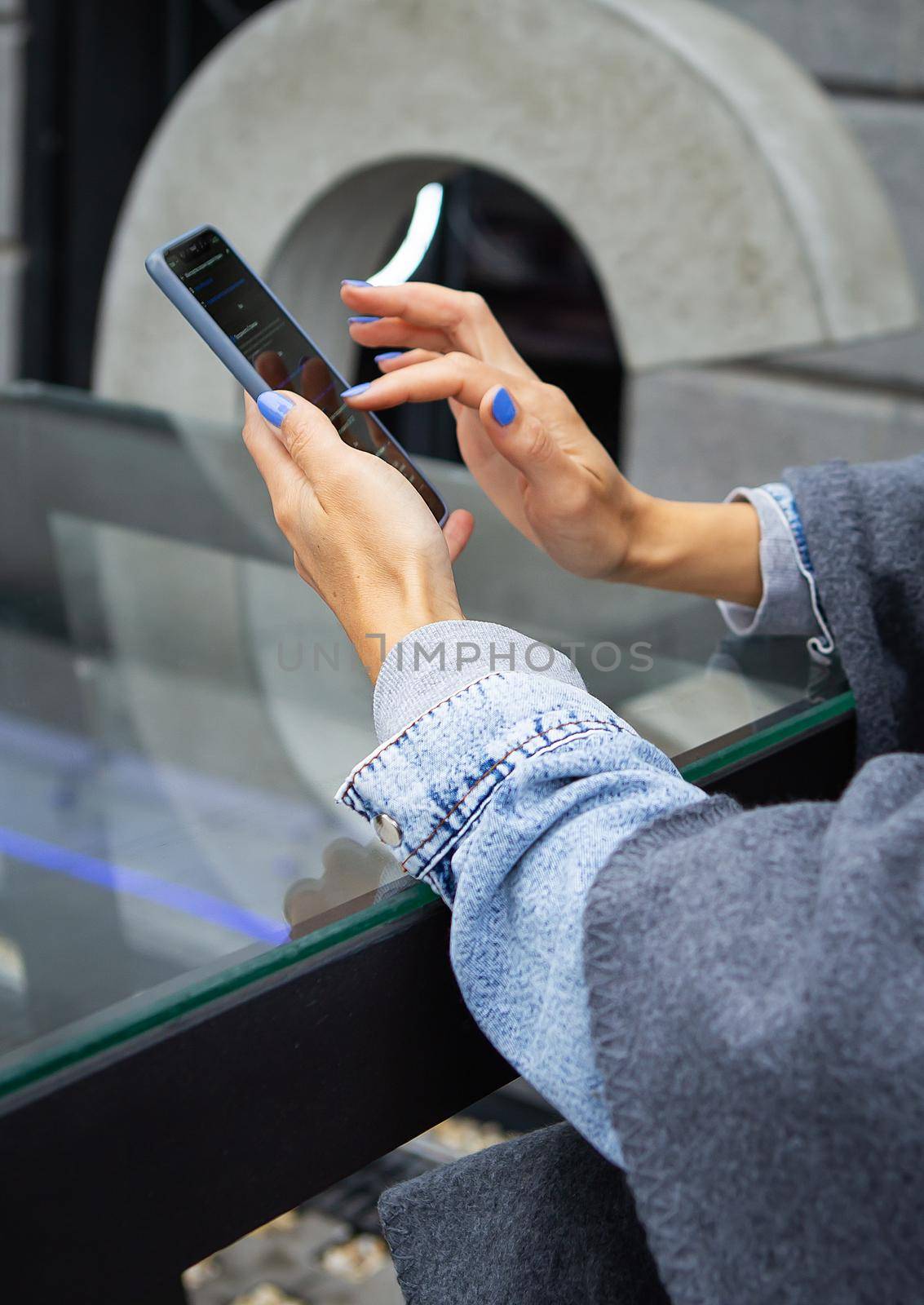 The girl sits in a cafe and holds a touch phone, a robot and communication via the Internet. Online robot, remote access