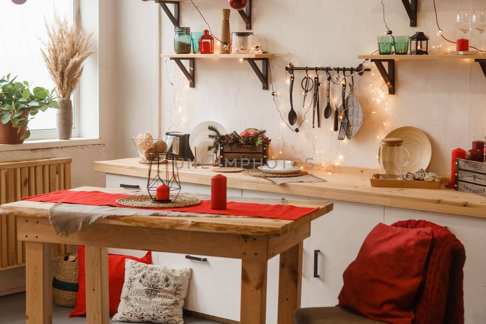 The kitchen is decorated in a Christmas style with red accents. Cozy atmosphere of winter holidays.