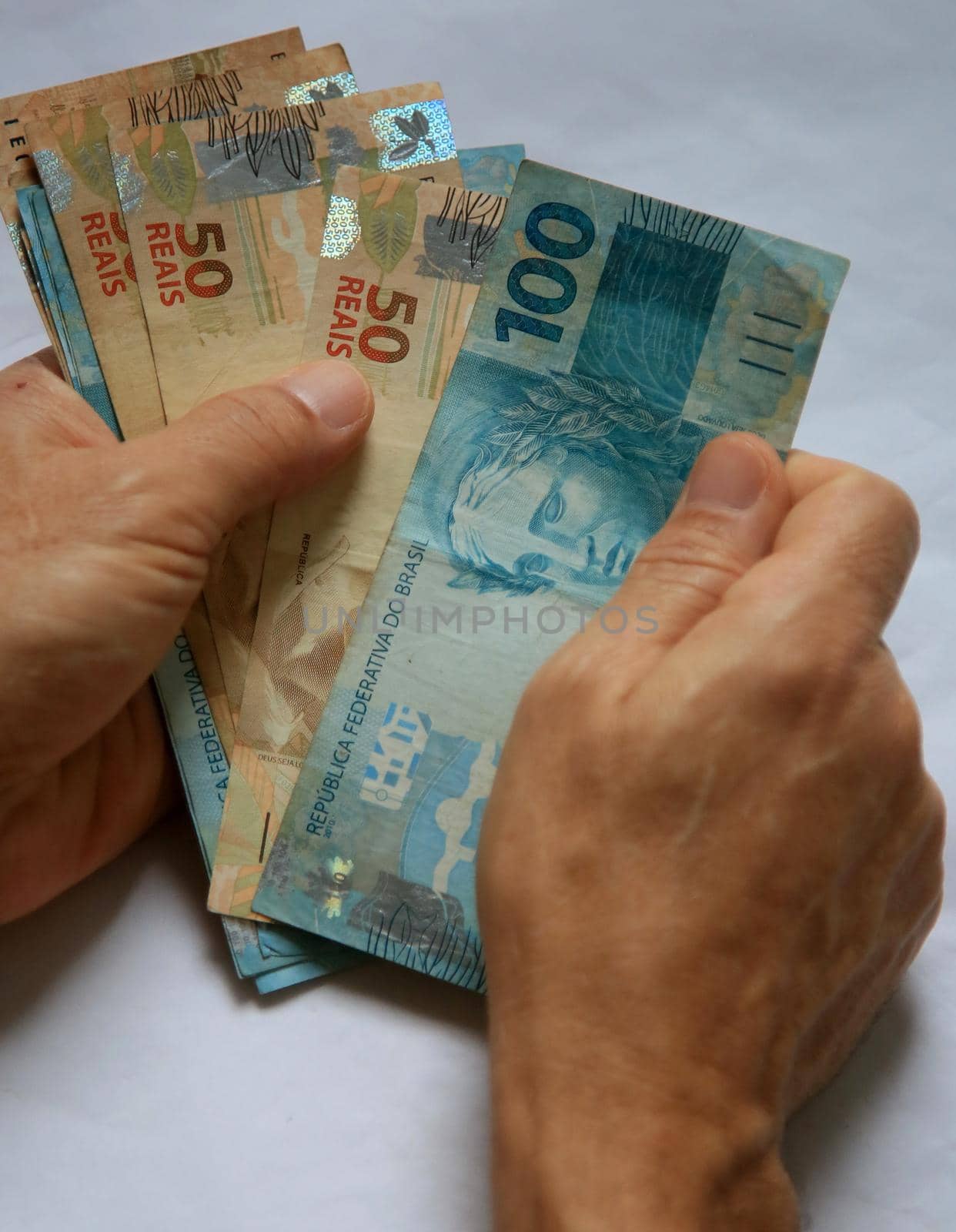 salvador, bahia / brazil - march 28, 2020: woman's hands hold reais banknotes, currency used in Brazil.