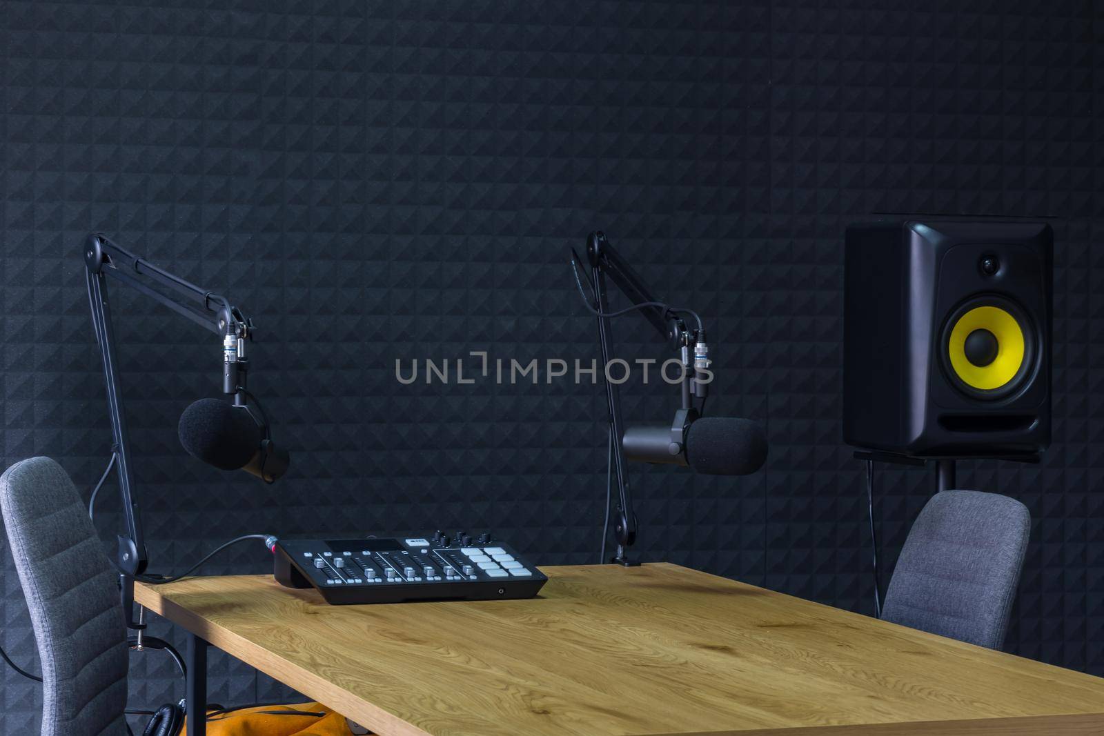 Podcast recording studio, with microphones and equalizer for recording online radio broadcasts, with black soundproof wall