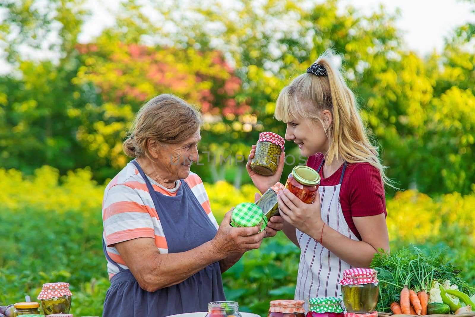 Women with jar preserved vegetables for the winter mother and daughter. Selective focus. Food.