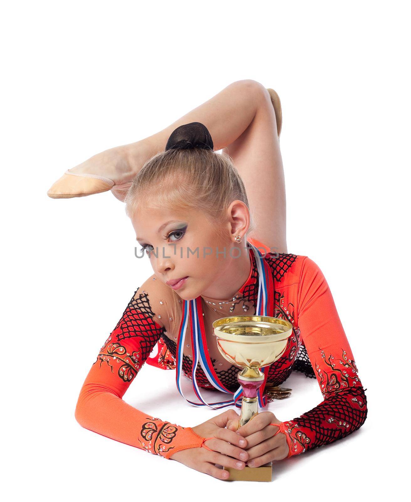 young gymnast lay with medals and prize cup isolated