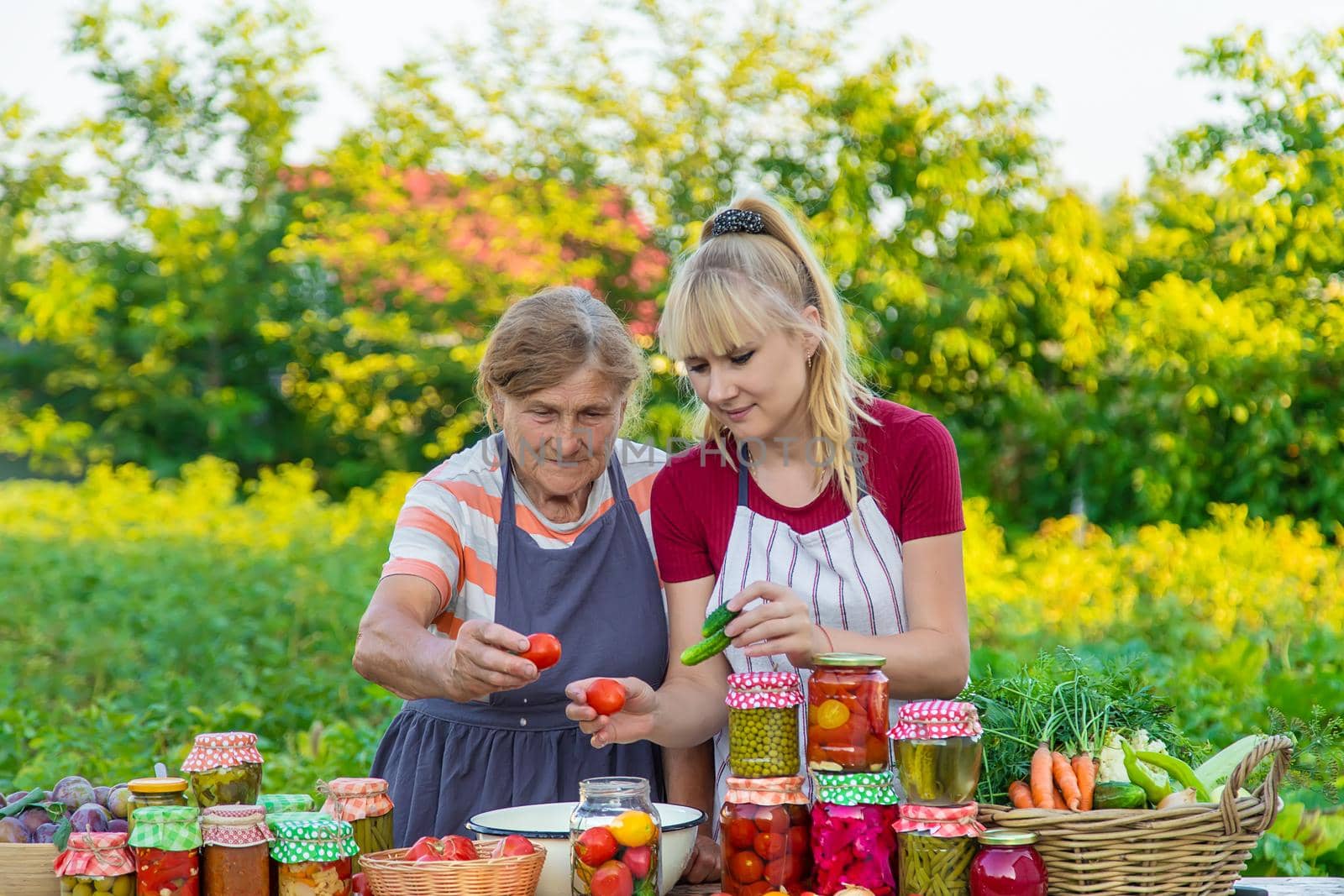 Women with jar preserved vegetables for the winter mother and daughter. Selective focus. Food.