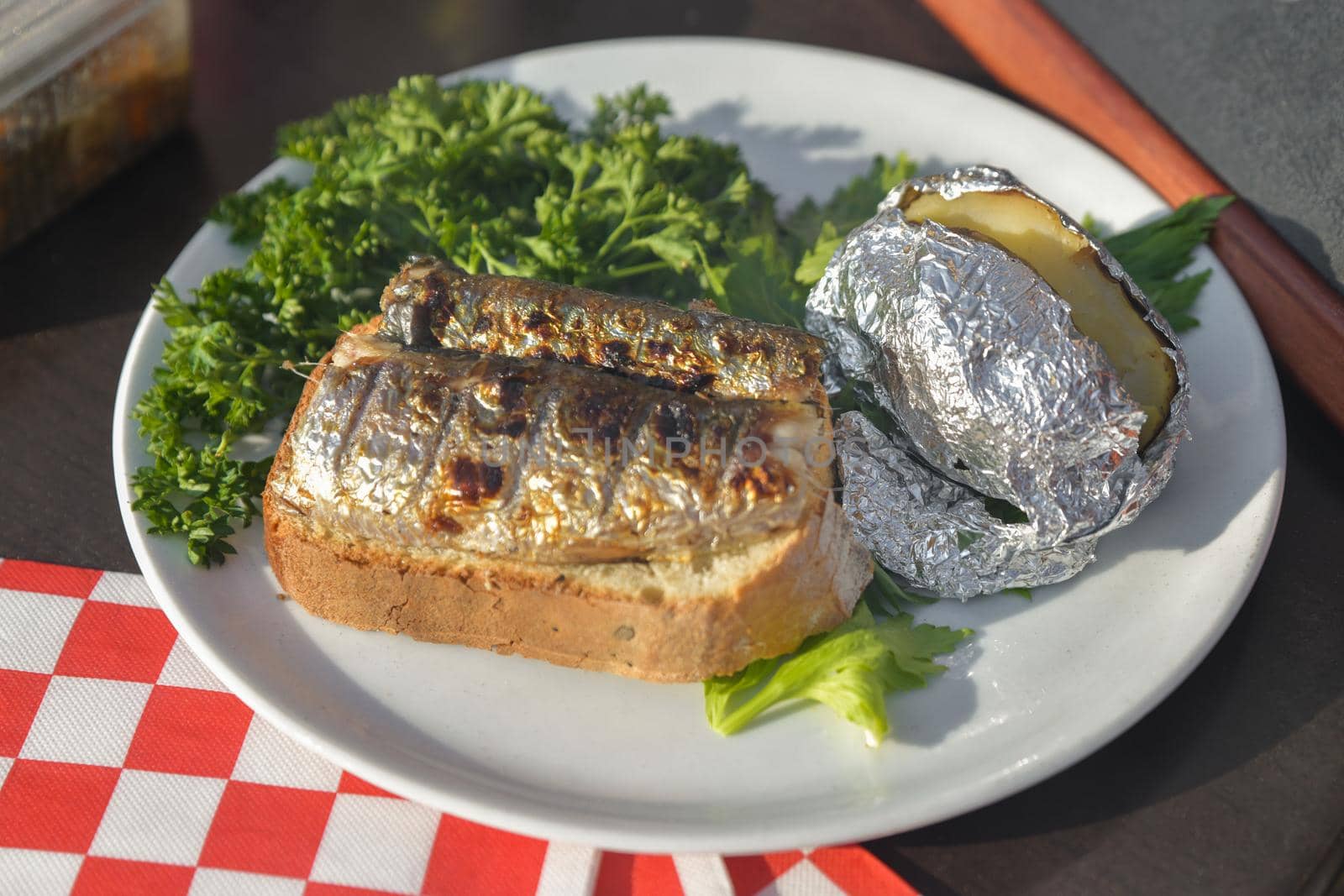 Herring grilled and baked in foil potatoes on a plate