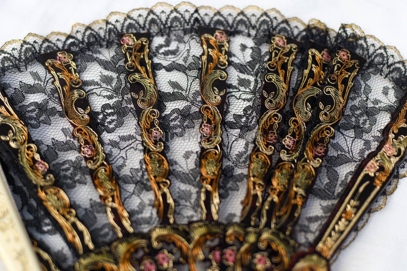 Open black fan with flowers at the flea market