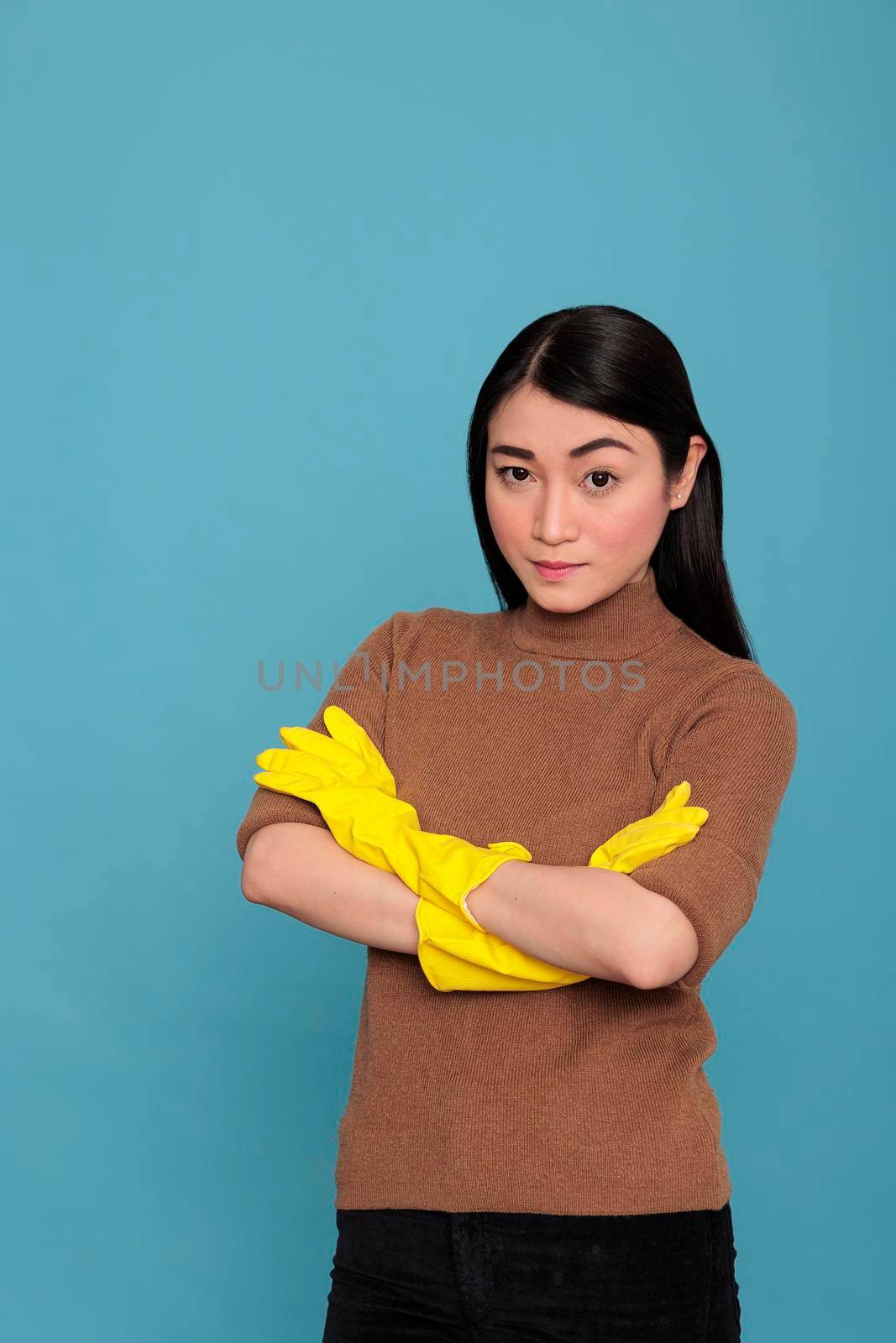 Sad unhappy and stressed asian housekeeper cross hand angry eyes with face expression wearing yellow gloves, Cleaning home concept, Tired frustrated female with negative state of mind