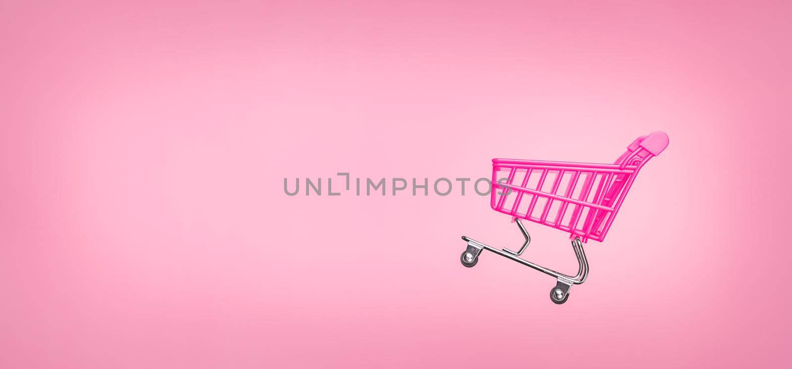 Sale cart shop banner E online. Empty trolley cart isolated pink background. Pink shopping trolley supermarket concept. Banner pink concept sales online shopping cart supermarket sales shopping symbol by synel