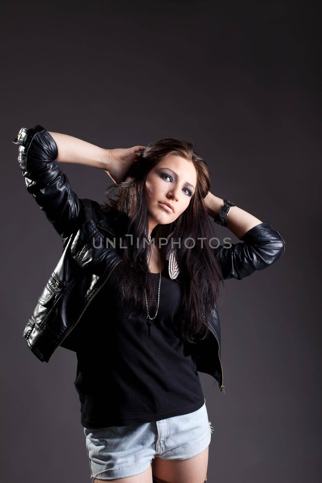 Sexy woman in grunge style stand in leather jacket look at camera