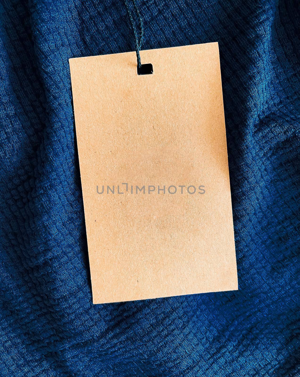 Blank fashion label tag, sale price card on luxury fabric background, shopping and retail concept