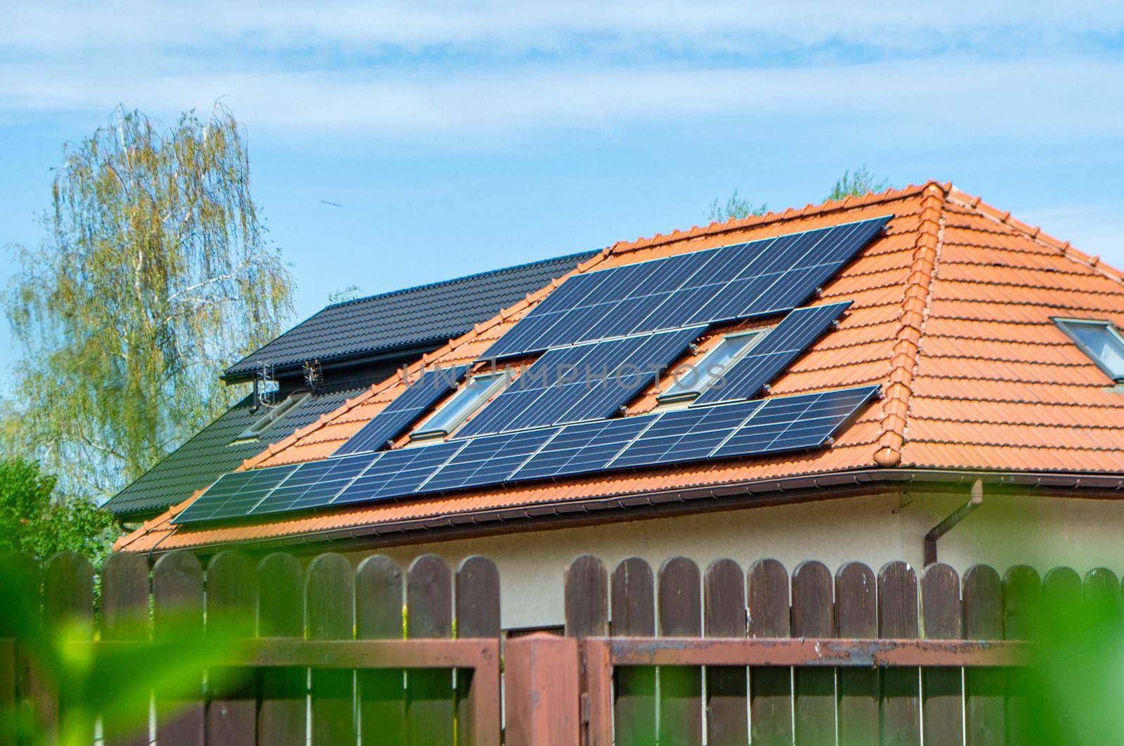 House roof with photovoltaic modules. Historic farm house with modern solar panels on roof and wall High quality photo