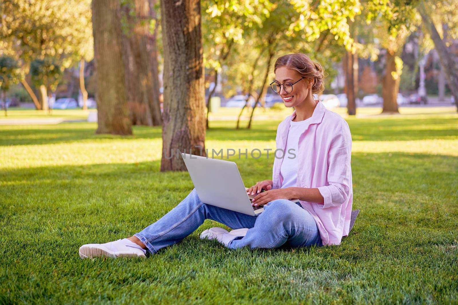 Businesswoman sitting grass summer park using laptop Business person working remote. Outdoor Successful european caucasian woman freelancer make video call teacher study work online lessons