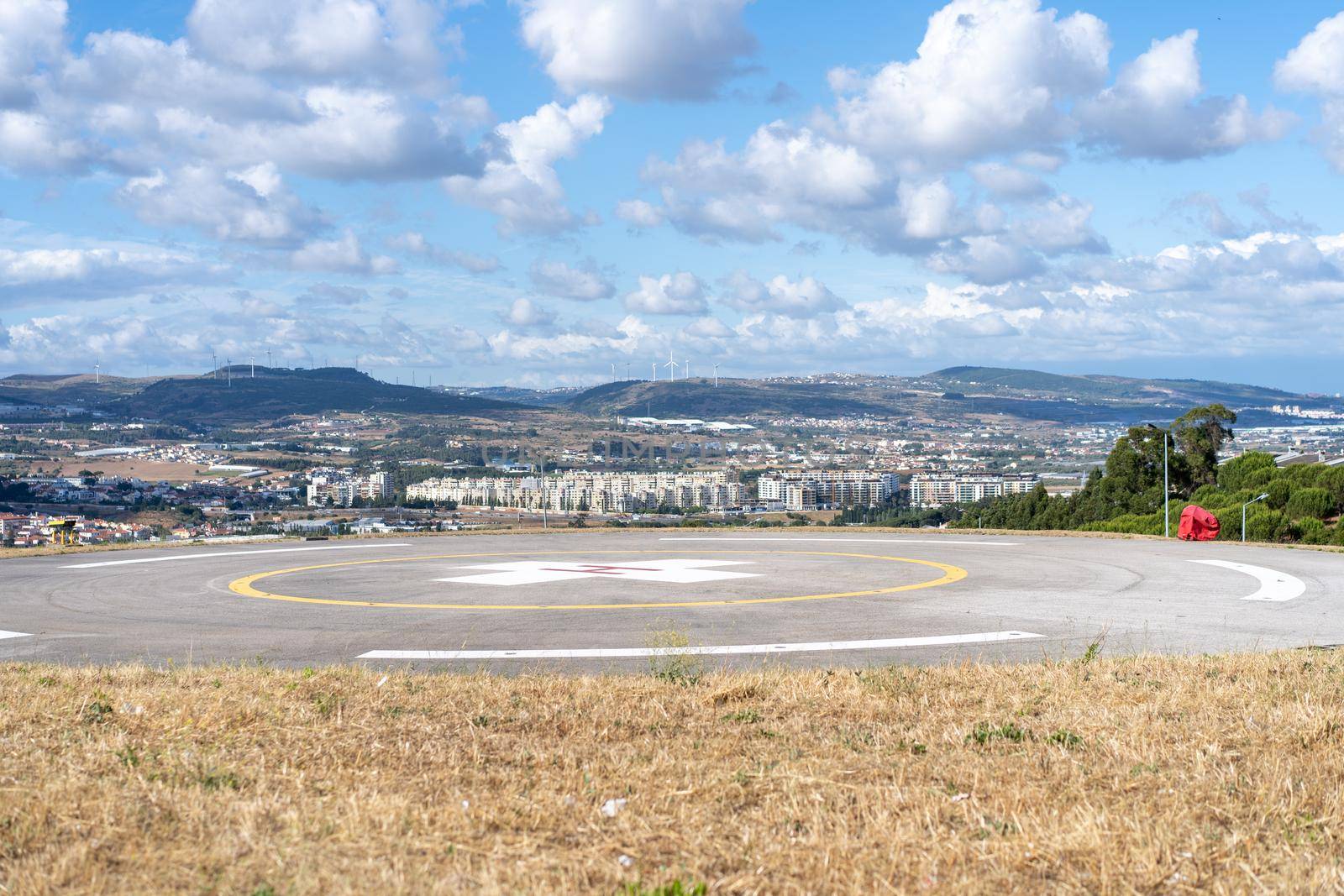 Helipad. Helicopter Landing Pad near emergency hospital in Portugal with cloud sky and city on background. Place to landing rescue helicopter near medical centre