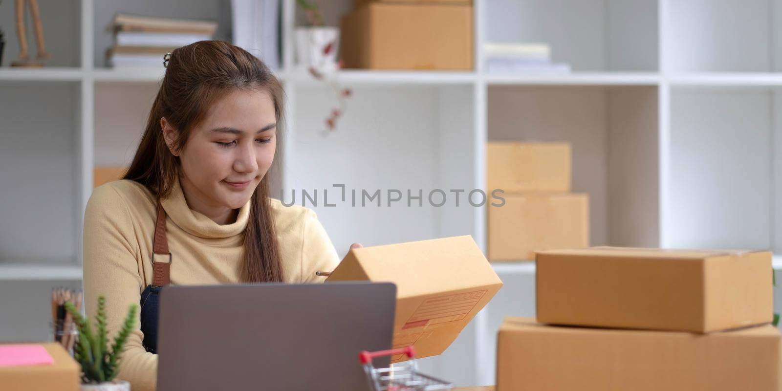 Portrait of Starting small businesses SME owners female entrepreneurs working on receipt box and check online orders to prepare to pack the boxes, sell to customers, sme business ideas online..
