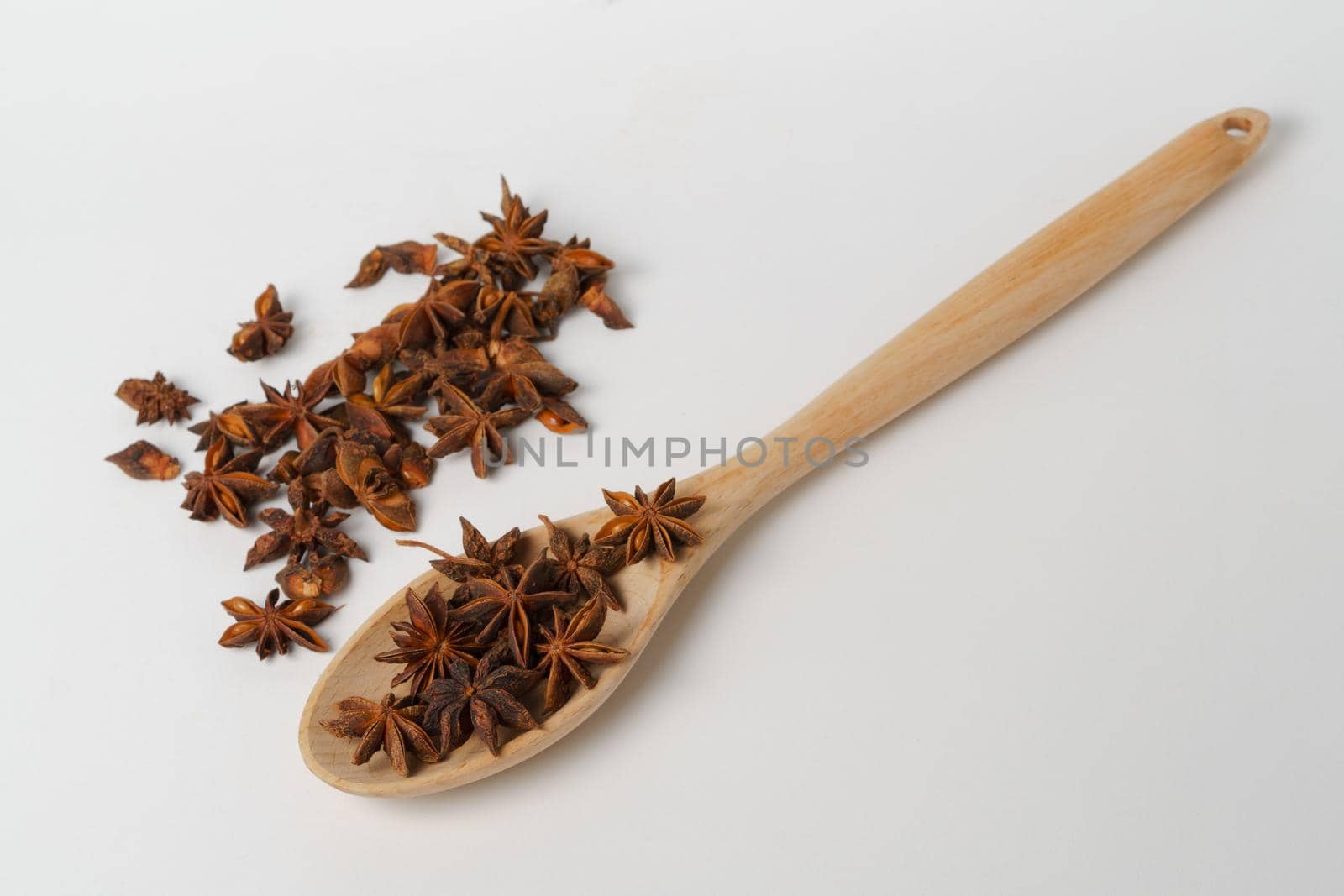 close-up of star anise illicium verum in a wooden spoon isolated on white background and copy space