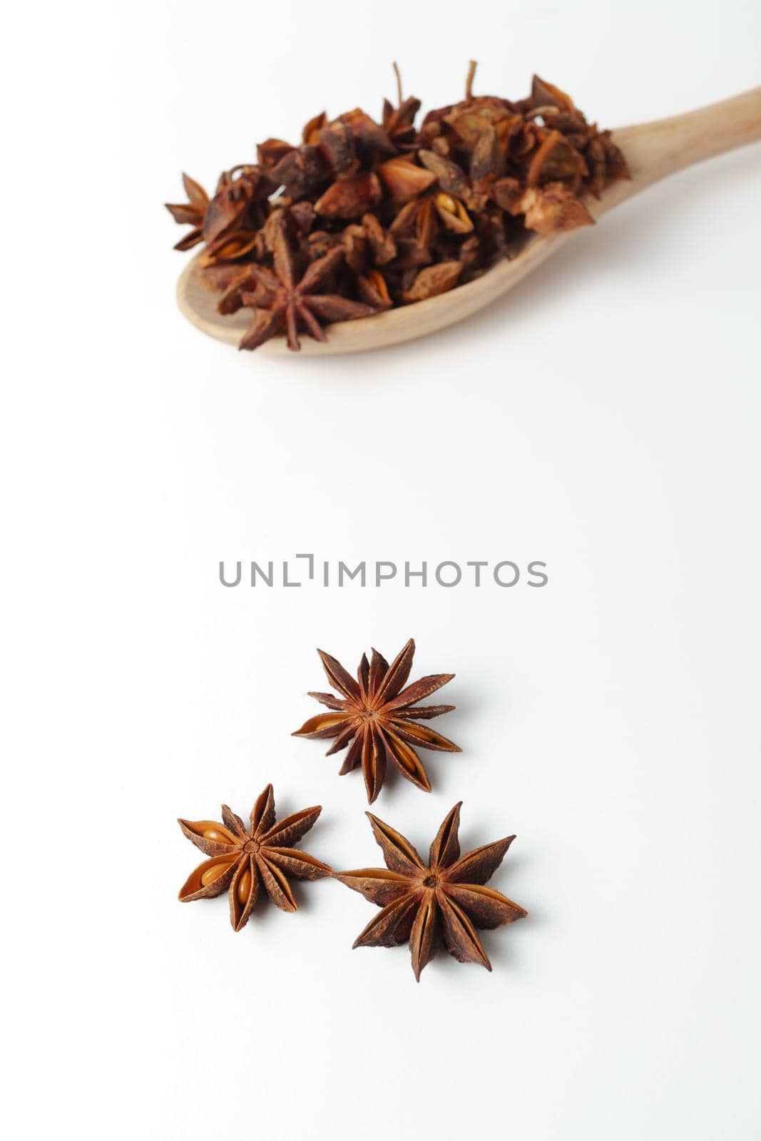 close-up of star anise illicium verum in a wooden spoon isolated on white background and copy space