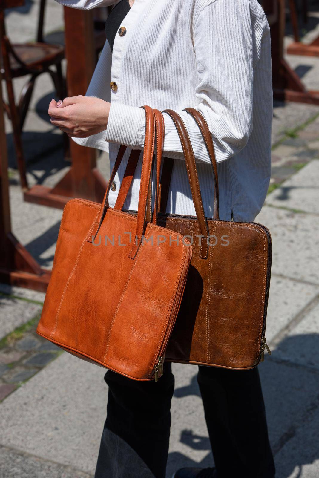 orange and brown leather bag. outdoors photo. Girl in a white jacket